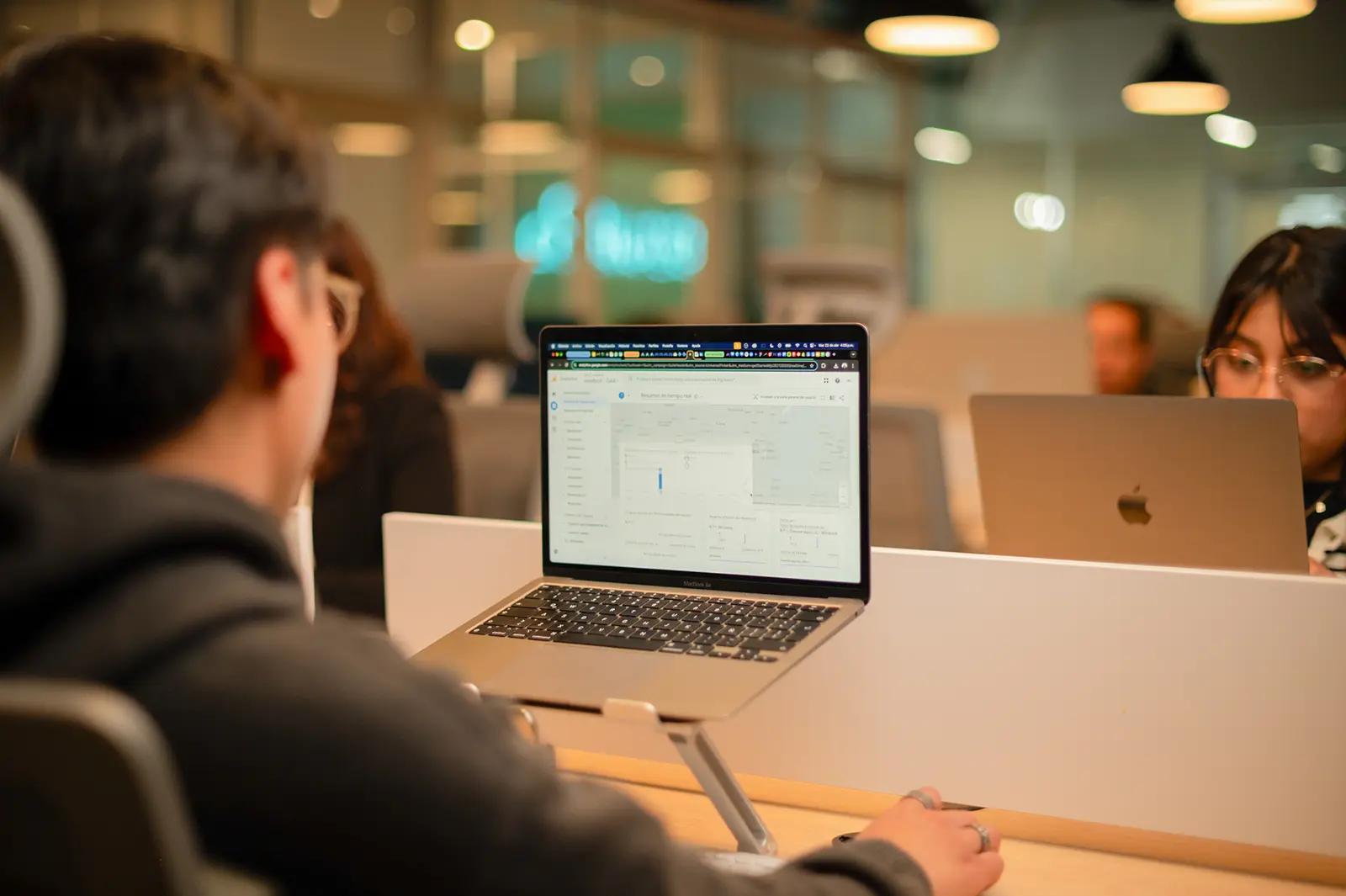 analisis Persona trabajando con portátil en oficina moderna