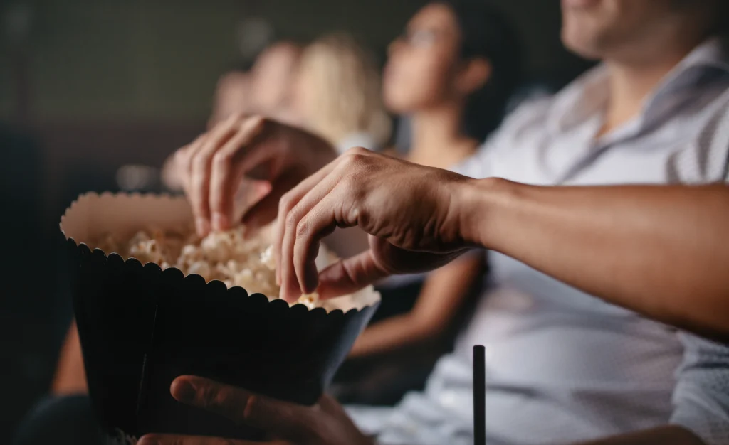 personas comiendo palomitas en el cine
