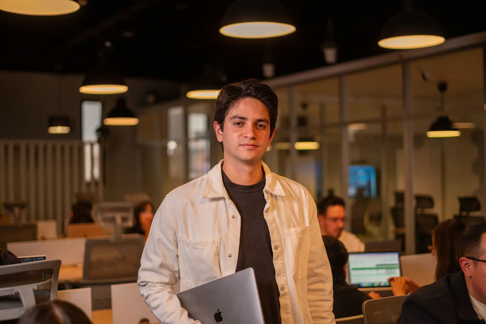 Hombre joven con portátil en oficina moderna